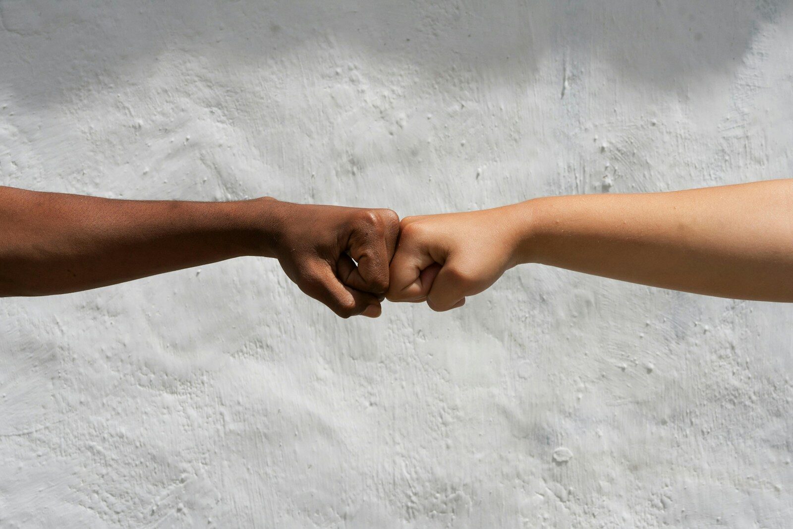 Diverse hands bump fists in solidarity